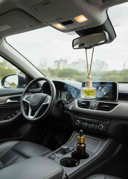 Car interior with a hanging car air freshener and a bottle of oil on the dashboard.