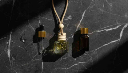 Small glass bottle with a dropper and cork on a dark marble surface